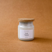 Musk Melody scented candle in glass jar with wooden lid on brown background